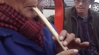  藏族老人演奏鹰笛